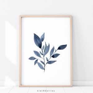May include: A watercolour painting of a blue leafy branch with a white background. The painting is framed in a light wood frame.