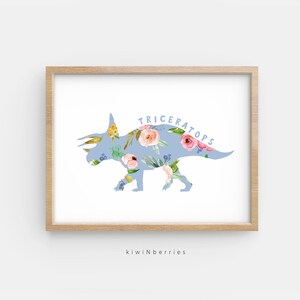 May include: A light blue silhouette of a Triceratops dinosaur with a floral pattern. The dinosaur is outlined in white and the text "TRICERATOPS" is written in blue letters above the dinosaur.