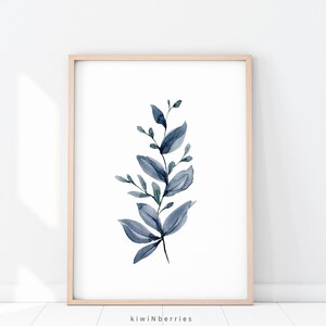 May include: A watercolour painting of a blue leafy branch with a white background. The branch is in a light wood frame.