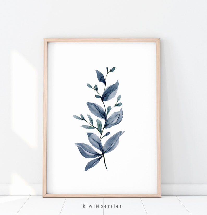 May include: A watercolour painting of a blue leafy branch with a white background. The branch is in a light wood frame.