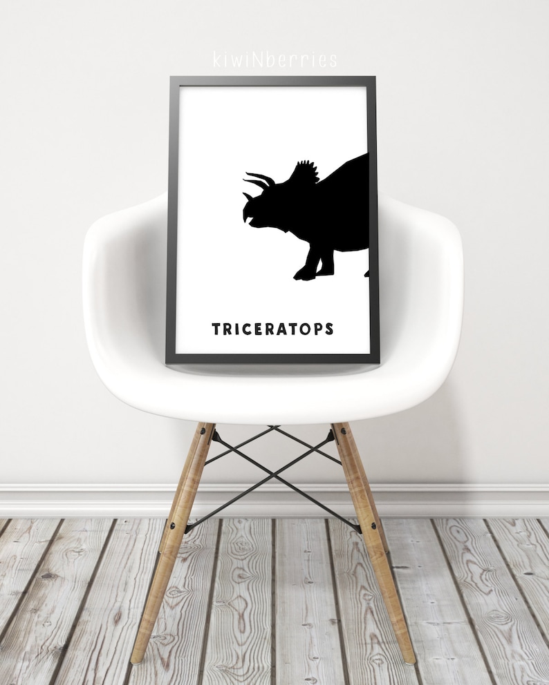 Op de afbeelding: Zwart-witte printbare kunstprint met een silhouet van een Triceratops-dinosaurus. De print heeft het woord "Triceratops" in zwarte tekst onder het dinosaurus-silhouet.