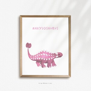 May include: Pink Ankylosaurus dinosaur illustration with white spikes and a club tail. The dinosaur is walking on a white background with the text "Ankylosaurus" above it and "kiwiNberries" below it.