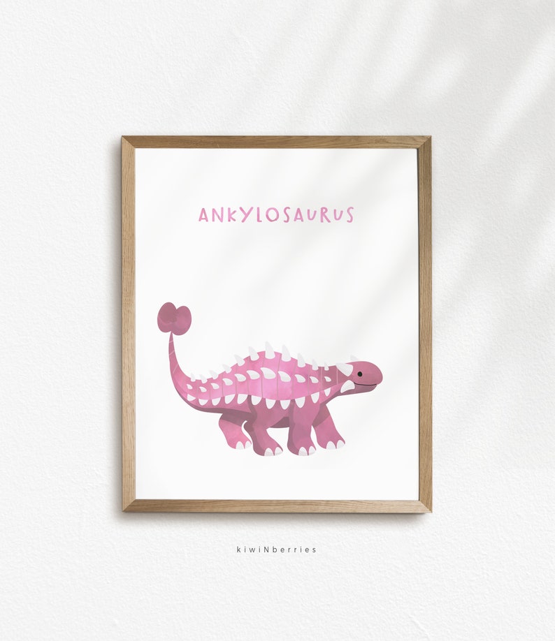 May include: Pink Ankylosaurus dinosaur illustration with white spikes and a club tail. The dinosaur is walking on a white background with the text "Ankylosaurus" above it and "kiwiNberries" below it.