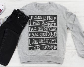 Pode incluir: Camisola cinzenta com texto preto que diz "Eu sou gentil, eu sou inteligente, eu sou importante, eu sou único, eu sou criativo, eu sou amado".