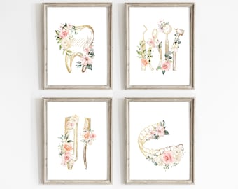May include: Set of four printable wall art prints featuring gold dental illustrations with pink and white floral accents. The prints include a tooth, dental tools, a toothbrush, and a set of teeth.