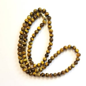 Impresionante collar vintage de cuentas redondas de ojo de tigre con cierre de rosca de metal dorado. Cuentas de 8 mm y 67 cm de largo.