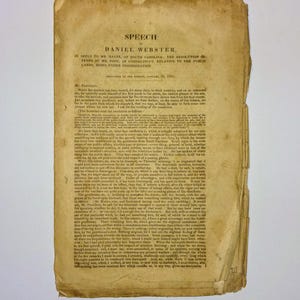 May include: A vintage document titled "SPEECH" by Daniel Webster. The aged paper has a yellowed, textured appearance with visible creases and wear. The text is printed in black ink, with the title and author's name prominently displayed at the top. The document is a historical artifact.