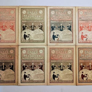 Puede incluir: Ocho n&uacute;meros antiguos de la revista The Eagle Magician de 1919 y 1920, cada uno con una ilustraci&oacute;n de portada de un mago actuando en el escenario, el t&iacute;tulo y un precio de 10 centavos impreso en la parte inferior de cada portada.