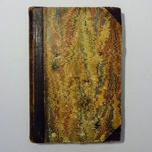 May include: A vintage book with a marbled cover in shades of brown, yellow, and green. The book has a dark brown leather spine.