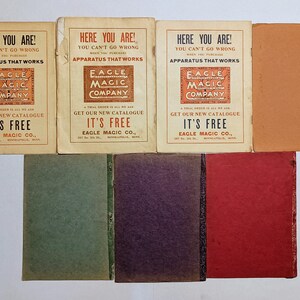 Puede incluir: Una colecci&oacute;n de siete folletos y libros antiguos. Tres folletos de color crema presentan el texto HERE YOU ARE! YOU CAN'T GO WRONG WHEN YOU PURCHASE APPARATUS THAT WORKS EAGLE MAGIC COMPANY. Cuatro libros de colores s&oacute;lidos son verde, morado, rojo y tostado.