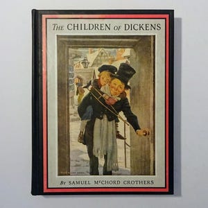 May include: A book cover with a red border and black background. The title "The Children of Dickens" is printed in white. The cover features an illustration of a man carrying a child on his back, walking through a doorway. The man is wearing a top hat and a scarf. The illustration is by Samuel McChord Crothers.