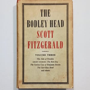 May include: A vintage hardcover book titled The Bodley Head Scott Fitzgerald Volume Three. The cream-colored cover features black and red text, including the titles This Side of Paradise, The Rich Boy, The Curious Case of Benjamin Button, and The Cut-Glass Bowl.