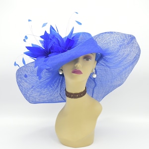 May include: A large, bright blue hat with a wide brim and a blue feather accent. The hat is made of a delicate, woven material and is perfect for a special occasion.