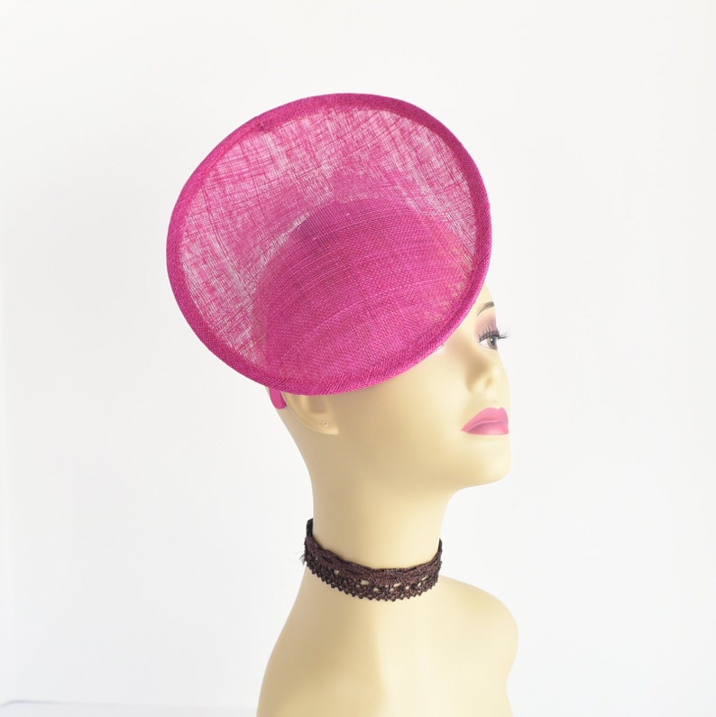 May include: A bright pink, round, wide-brimmed hat made of straw.