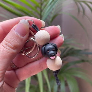 May include: Black dog charm keychain with wooden beads and a silver key ring.