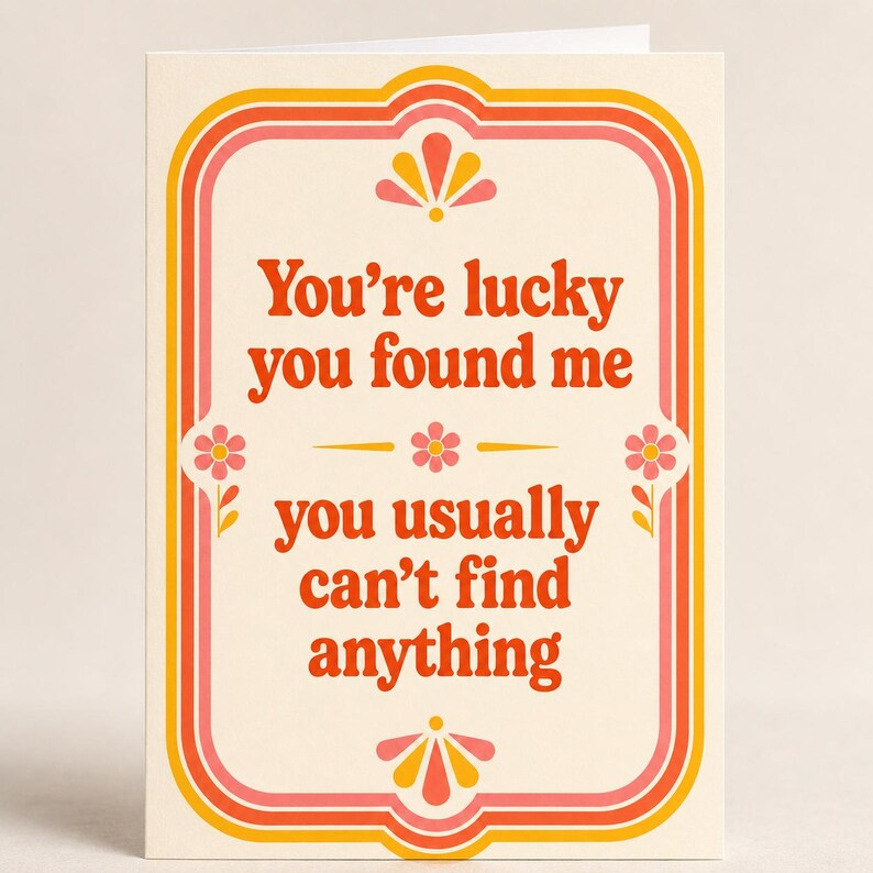 May include: A cream-colored greeting card featuring a decorative border in shades of orange, pink, and yellow. The text reads, "You're lucky you found me you usually can't find anything," accented by small floral and fan-shaped graphic illustrations.