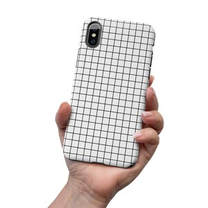 May include: A white phone case with a black grid pattern. The case has a camera cutout in the upper left corner.
