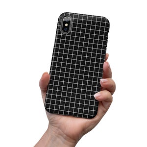 May include: Black phone case with a white grid pattern. The case has a camera cutout in the upper left corner.
