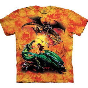 Könnte beinhalten: Ein Batik-T-Shirt mit einem grafischen Druck eines Kriegers, der auf einem Drachen reitet und gegen einen anderen Drachen kämpft. Der Hintergrund ist in einem feurigen Orange und Gelb gehalten.