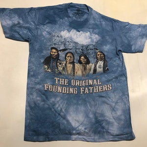 May include: A blue tie-dye t-shirt with a graphic of five Native American men and the text "The Original Founding Fathers".
