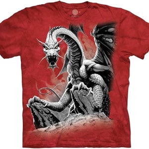 Pode incluir: Camiseta vermelha com um gráfico de dragão branco. O dragão é retratado com as asas abertas e as garras estendidas. O dragão é colocado sobre um fundo vermelho com um efeito de fumaça branca.