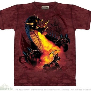 Pode incluir: Uma camiseta tie-dye vermelha, preta e laranja com uma estampa gráfica de um dragão respirando fogo e um arqueiro atirando uma flecha no dragão.