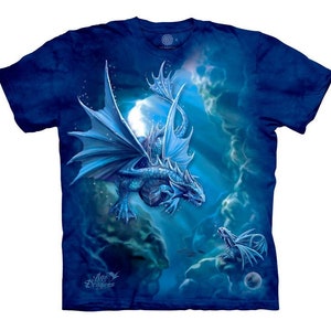 Pode incluir: Uma camiseta azul tie-dye com um gráfico de um dragão azul voando em um céu nublado. O dragão tem um dragão menor voando atrás dele. O texto "Aqua Dragons" está impresso no canto inferior esquerdo da camiseta.