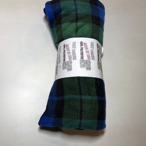 Puede incluir: Una manta de forro polar a cuadros verde, azul y negro enrollada con el texto "COZY CORNER THROWS MADE IN USA 100% POLYESTER 60X60" impreso en la etiqueta.