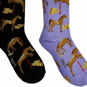 May include: A pair of socks with a purple and black background. The socks feature a repeating pattern of horses jumping over hurdles. The socks are labeled "Foozy's".
