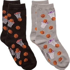 May include: A pair of socks with a basketball theme. One sock is black with white and orange basketballs and nets. The other sock is gray with white and orange basketballs and nets. The socks have the text "Foozy's" on them.