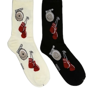 May include: A pair of socks with a white sock featuring a boxing glove and a bell, and a black sock featuring a boxing glove and a bell.