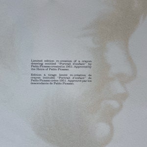May include: A limited edition re-creation of a crayon drawing titled "Portrait d'enfant" by Pablo Picasso, created in 1951. The image features a faded, sepia-toned portrait of a child's profile, with text describing the artwork.