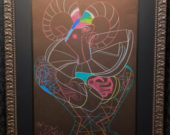 May include: Abstract artwork of a ram in a black frame. The artwork features a brown background with a colorful outline of the ram's head and body. The ram's horns are white, and the artwork is signed.