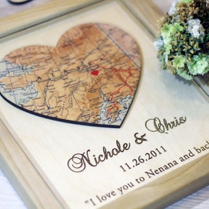 Close-up of custom map art on wood. Features a detailed map of Alaska with a personalized heart marker. Texture of the natural wood is visible, highlighting the rustic style perfect for a 5th anniversary wood gift.