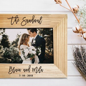 Personalized wedding gift for couples. Custom engraved wooden picture frame featuring the family surname and wedding date. Rustic farmhouse style decor, perfect for bridal shower gifts or anniversary presents.
