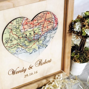 Completed custom wedding gift for a Louisiana couple. Angled view of a wooden shadow box frame with a vintage map heart and custom engraving. A unique 5th-anniversary wood gift idea.