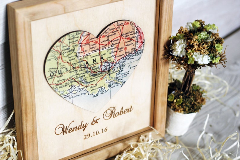 Completed custom wedding gift for a Louisiana couple. Angled view of a wooden shadow box frame with a vintage map heart and custom engraving. A unique 5th-anniversary wood gift idea.