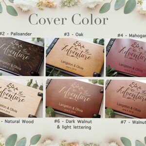 A product showcase image titled "Cover Color" featuring six different wood finish options for a personalized wooden adventure Photo album. The finishes include Palisander, Oak, Mahogany, Natural Wood, Dark Walnut with light lettering, and Walnut. Each book is laser-engraved with "The Adventure," names "Langston & Olivia," a date, and an outdoor mountain and camping illustration.