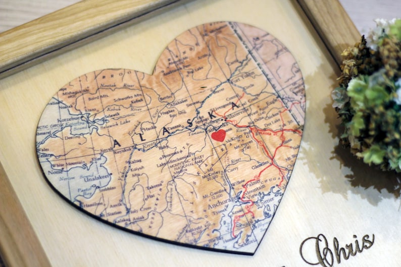 Custom map heart gift for long-distance relationships. Detail view of a personalized Alaska map with a red heart marking a special place. A sentimental 5th-anniversary wood gift or 'where we met' keepsake for couples.