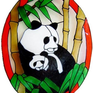 May include: A stained glass artwork featuring a black and white panda bear with a baby panda in a bamboo forest setting. The artwork is decorated with red, white, and green colours.
