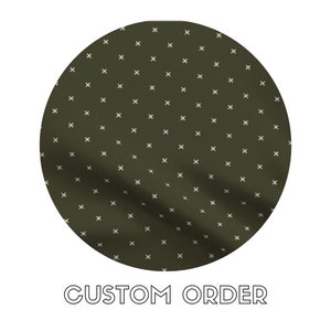 Puede incluir: Una tela verde oscuro con un patrón de cruces blancas. La tela es texturizada y tiene un ligero brillo. El texto "CUSTOM ORDER" está impreso debajo de la tela.