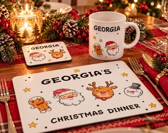 Puede incluir: Una taza de cerámica blanca, un posavasos cuadrado y un mantel individual rectangular, todos con el nombre Georgia e ilustraciones festivas de Papá Noel, un hombre de jengibre, un reno y un muñeco de nieve con estrellas amarillas.