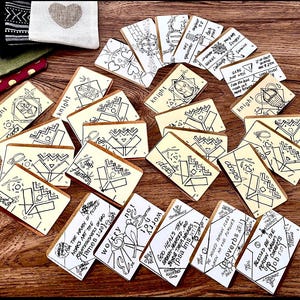 May include: A collection of small, rectangular cards with various designs and text. The cards feature black and white illustrations and text, including phrases like "roots", "knight", "Flames", "ideas", "worry not", "God heals the broken-hearted", and "Proverbs 28:11".