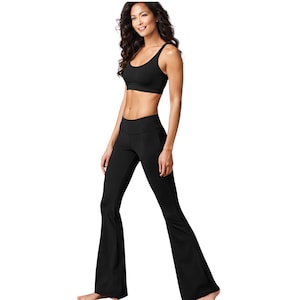 May include: A black athletic sports bra with a scoop neckline and matching black high-waisted flared leggings. The set is solid black, featuring a fitted top and trousers that widen from the knee down to the hem, creating a flared silhouette.
