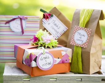May include: Four gift bags with colorful striped and patterned paper, decorated with tags that say "Thanks for coming".