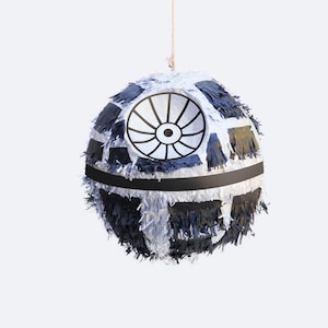 May include: A white and black Star Wars Death Star piñata with a black string hanging from the top.