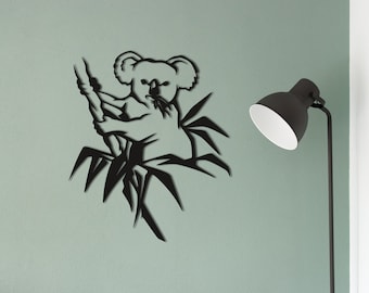 May include: Black metal wall art featuring a koala bear climbing a bamboo tree. The koala is in a sitting position with its arms wrapped around the bamboo.