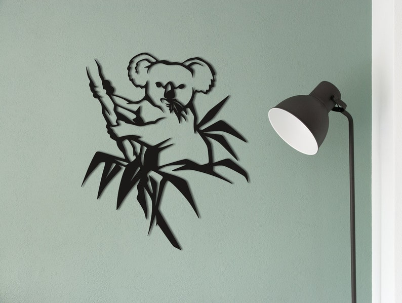 May include: Black metal wall art featuring a koala bear climbing a bamboo tree. The koala is in a sitting position with its arms wrapped around the bamboo.