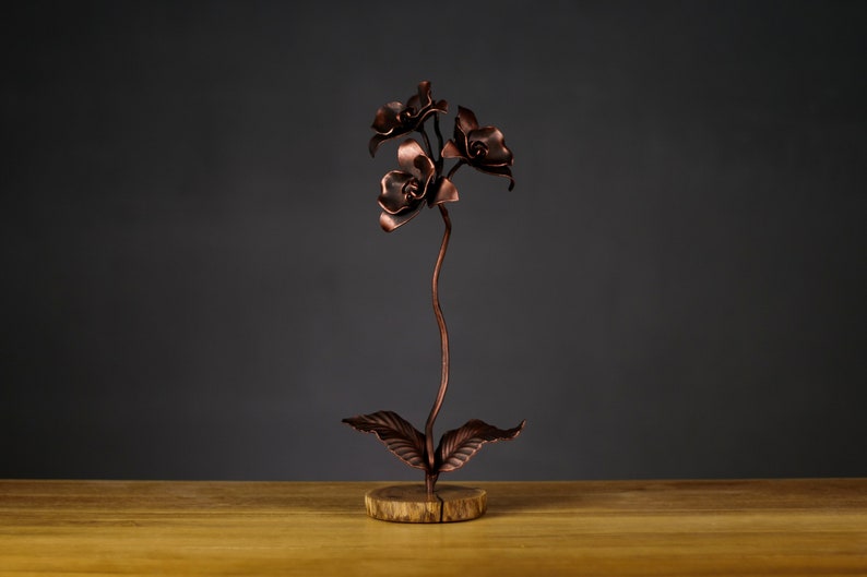 Stahlorchidee auf einem Holzständer. Geschmiedete Orchidee. Orchidee aus Metall. Vollständig handgefertigt. Ewige Orchidee Kupfer