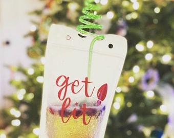 May include: A clear plastic pouch with a green straw and a red and white "get lit" design. The pouch is filled with a light-colored beverage.